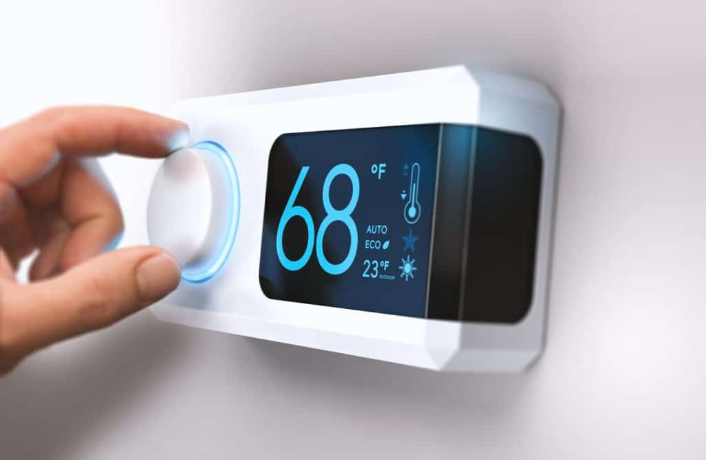 Hand turning a home thermostat knob